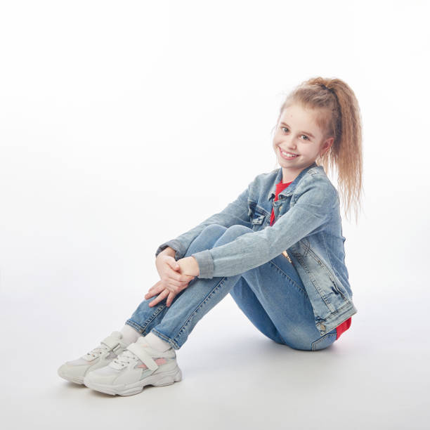 istock Young girl wearing denim sitting on floor 1217558005