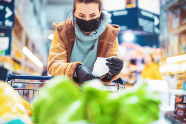 istock Young woman looking at her shopping list 1217558337