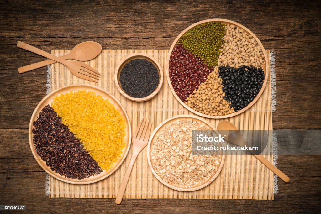 Various type of cereal grains,Wheat, rice, brown rice, buckwheat, barley, black sesame, millet,5 colors beans, black beans, red beans, white beans, green beans, soybean.on wood background Agriculture Stock Photo