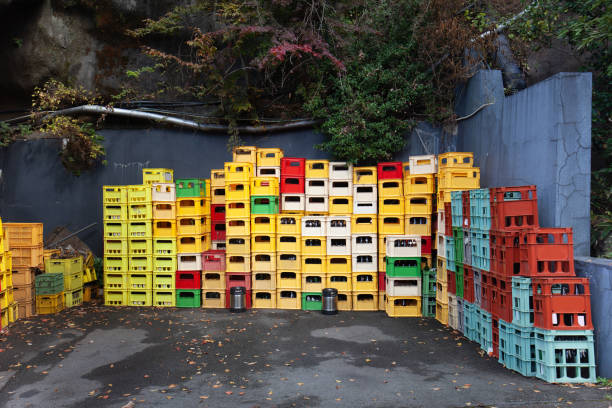 Close up of stacks of plastic red, white, and yellow crates containing beer and soft drink bottles in Japan. Stacked Multicolored Plastic Beer Crates. Plastic Old Boxes. deposit bottle stock pictures, royalty-free photos & images