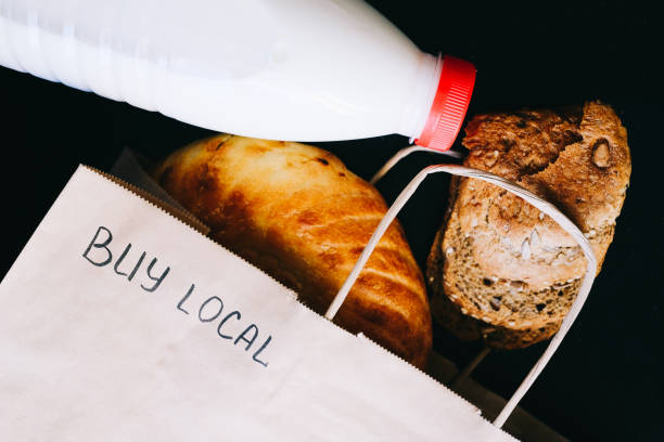 istock Buy local. milk and bread on a black table with a craft bag 1217562983