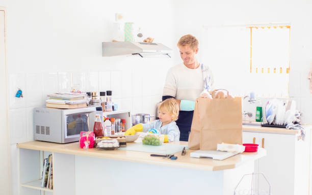 istock a Father and son disinfecting the groceries. 1217563102