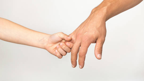 istock Son holding his daddy's finger, white studio background 1217564558