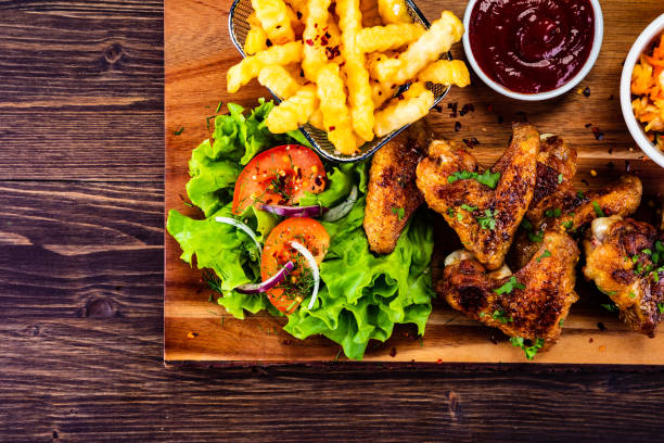 alas de pollo a la barbacoa y verduras en tabla de madera - roast chicken barbecue chicken french fries chicken fotografías e imágenes de stock