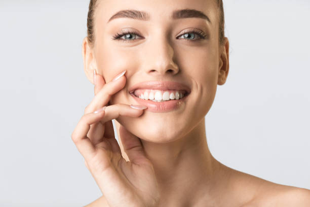 istock Pretty Blonde Girl Touching Lips Smiling To Camera In Studio 1217564978