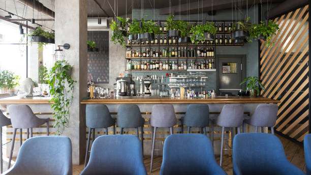istock Modern wooden counter zone in empty cafe, green plants 1217565422