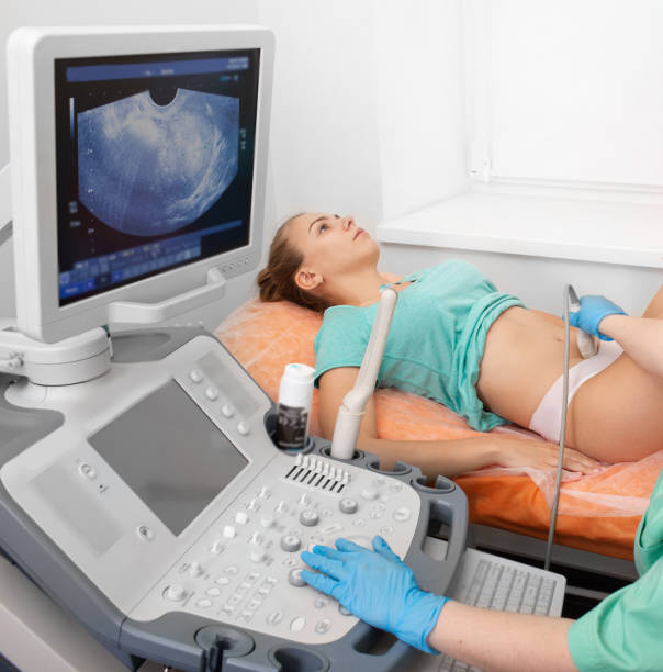 jeune patient pendant l’examen d’ultrason ovarienne. santé des femmes, examen par un gynécologue - human pregnancy ultrasound medical exam doctor photos et images de collection