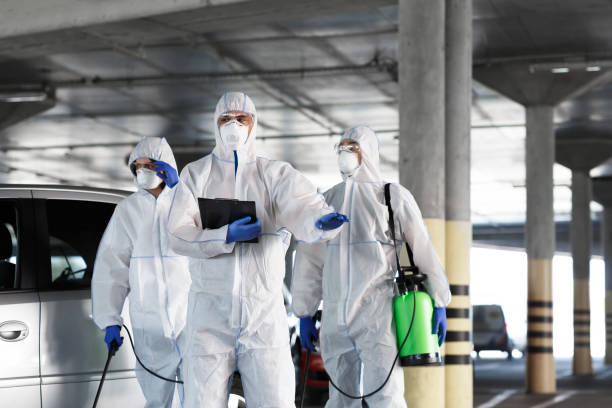 Virologists in protective suits on duty on public parking for first aid Virologists in protective suits on duty on public parking for first aid, coronavirus, epidemic, panorama, copy space biohazard cleanup stock pictures, royalty-free photos & images