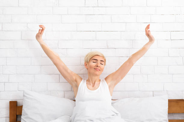 istock Beautiful middle aged woman waking up in her bed 1217567191