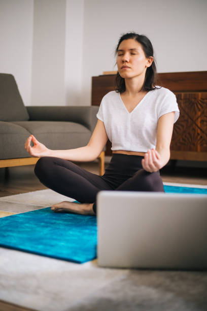 istock Self learning. Woman using laptop to training yoga 1217568377