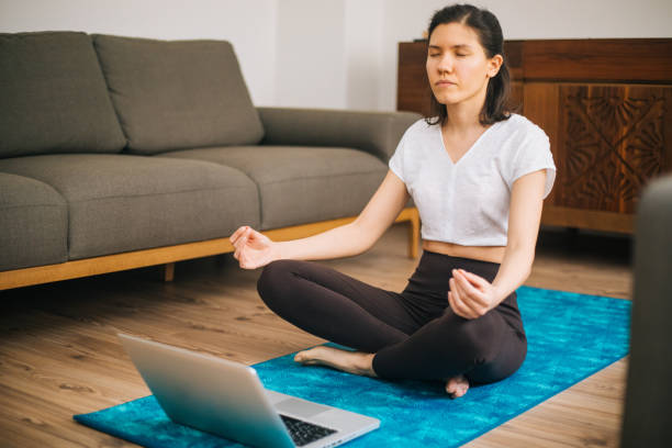 istock Self learning. Woman using laptop to training yoga 1217568887