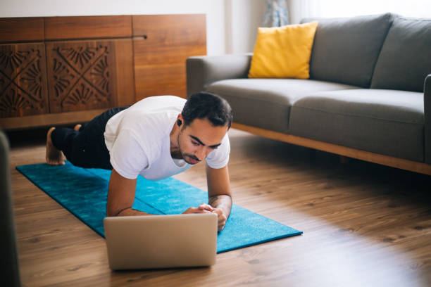 człowiek używa laptopa do chudego stanowiska deski - living room learning healthy lifestyle one person zdjęcia i obrazy z banku zdjęć