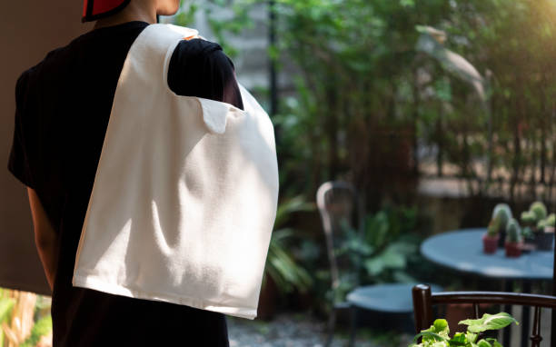istock Man is holding bag canvas fabric for mockup blank template on restaurant background. 1217570413