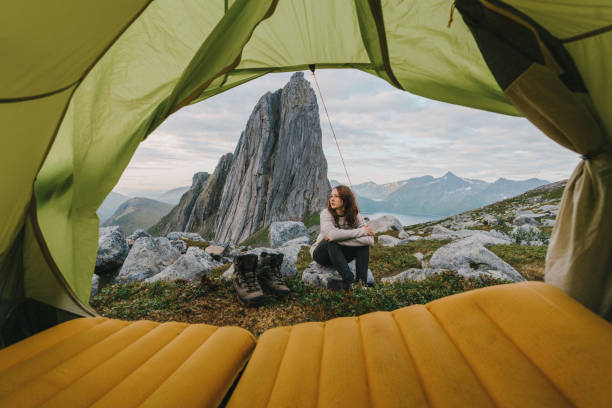 Woman sitting outside of tent in  Senja Island in  mountains Young Caucasian woman  sitting outside of tent in  Senja Island in  mountains senja island photos stock pictures, royalty-free photos & images