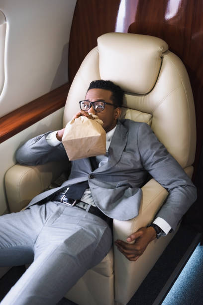 개인 비행기에 비행 하는 동안 공황 발작을 하는 동안 종이 가방으로 호흡 하는 아프리카 계 미국인 사업가 스트레스 - fear airplane flying business travel 뉴스 사진 이미지