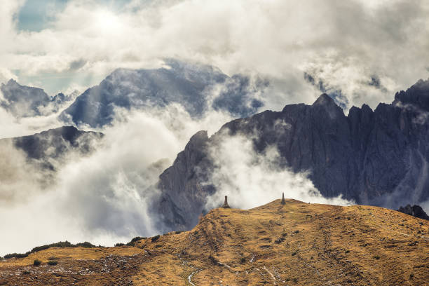 istock Dramatic rocky mountains in the clouds and sun shining 1217573627