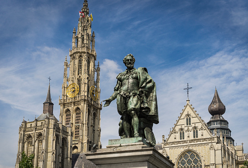 Statue of the Flemish painter Rubens in a square in the Belgian city of Antwerp with the cathedral in the background.