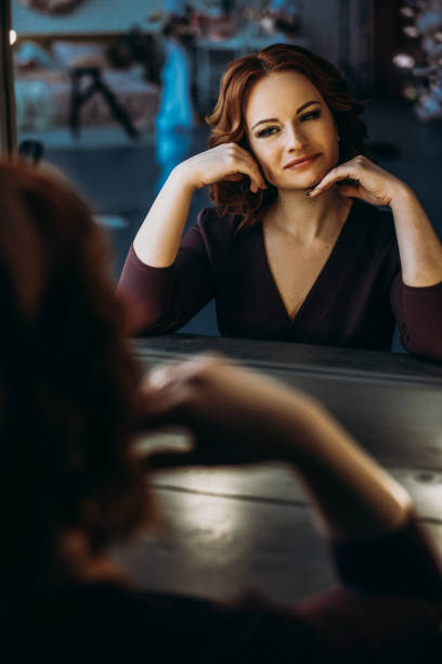istock Beautiful redhead women looking in mirror at herself 1217576370