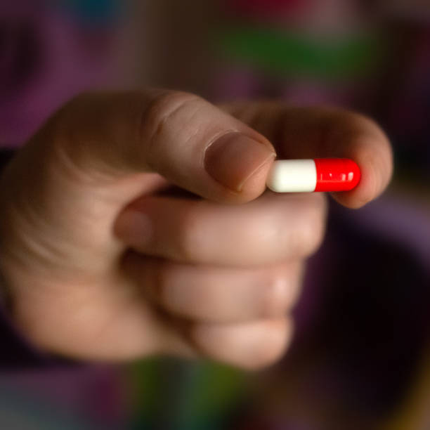 istock Hand holding a bicolor pill and antiviral text on it 1217579518