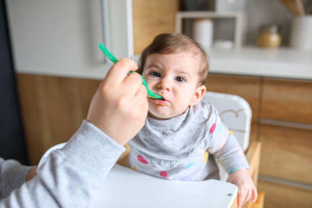 istock Mother feeds baby from spoon 1217581489