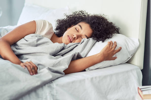 There's no time like nap time Shot of a young woman sleeping peacefully in her bed sleeping stock pictures, royalty-free photos & images