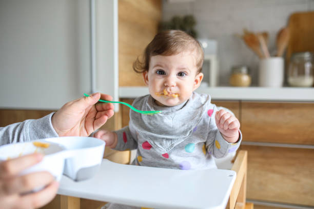 istock Mother feeds baby from spoon 1217582632