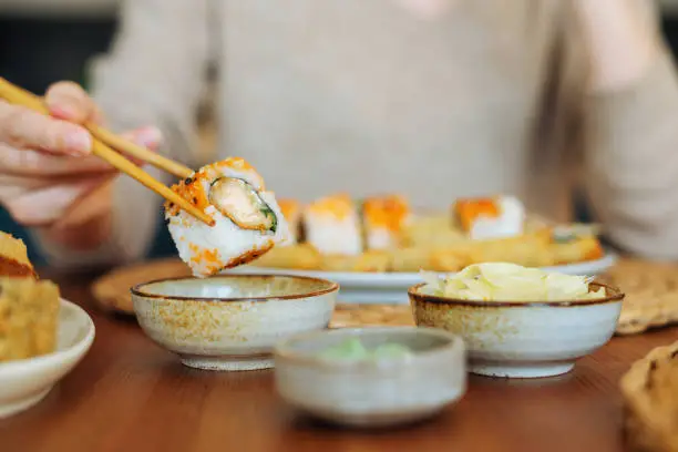 Photo of Woman eating sushi rolls