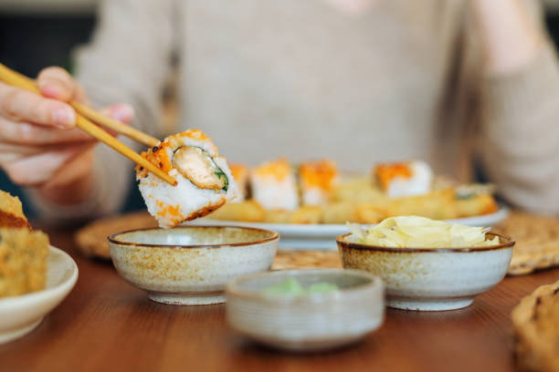 woman eating sushi rolls - sushi imagens e fotografias de stock