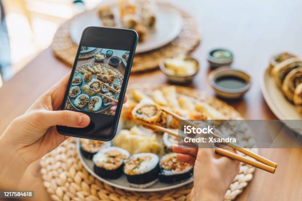 Woman Taking Photo Of Maki Sushi With Smartphone Stock Photo - Download Image Now - Sushi, Food, Eating