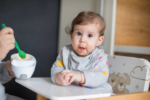 istock Mother feeds baby from spoon 1217584654