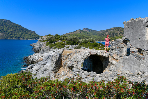 Female tourist travels in ruins on the island.