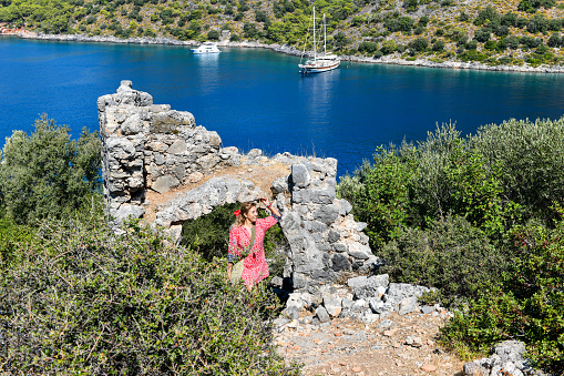 Female tourist travels in ruins on the island.