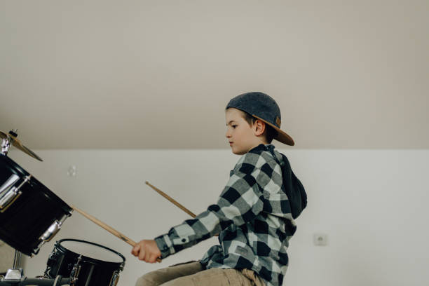 istock Little boy practicing drums at home 1217585860