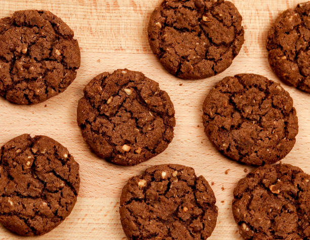 istock Chocolate cookies with nuts on a wooden cutting board 1217587408