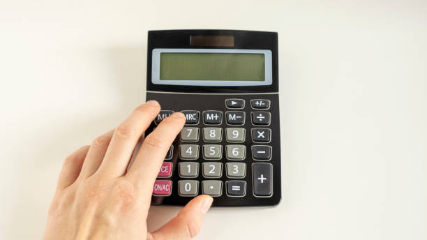 istock Close-up Hand Holding Calculator Over White Background 1217587609