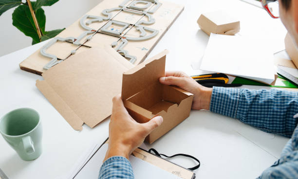 istock Box maker in glasses and checkered shirt holding box in hands 1217589020