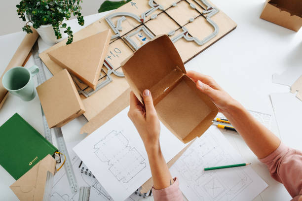 istock Woman hands holding folded newly made box 1217589066