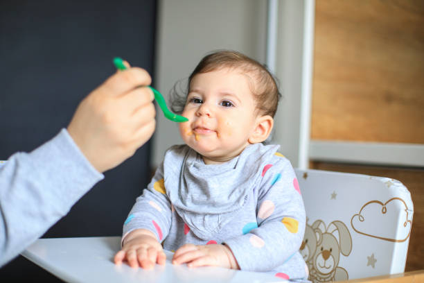 istock Mother feeds baby from spoon 1217589125