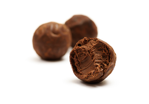 Bitten chocolate truffle isolated on white background