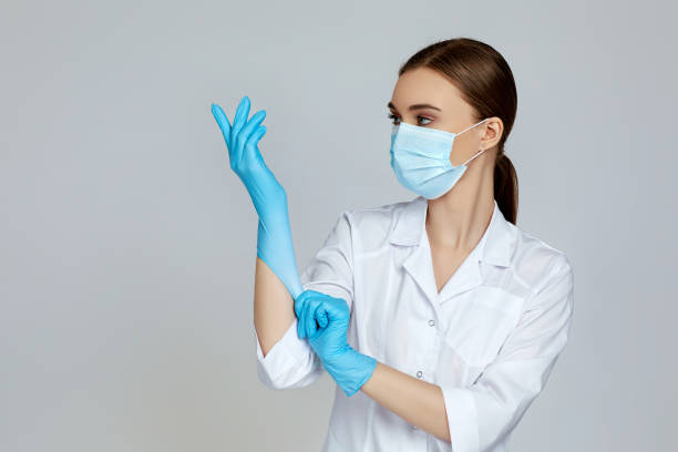 istock doctor in white uniform wearing mask and rubber gloves 1217593450