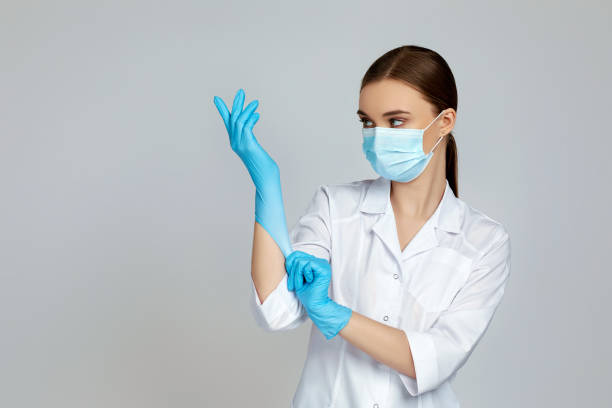 istock doctor in white uniform wearing mask and rubber gloves 1217593470