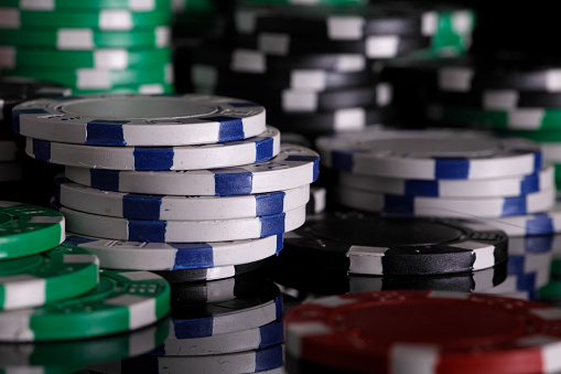 chips for poker games, chips, reddish green and black isolated on a black background