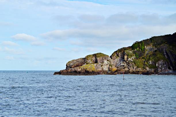 istock Quiet sea waters against a cliff and blue sky 1217600984