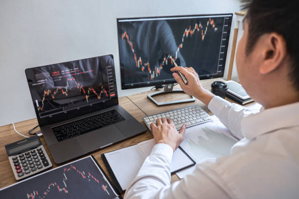 istock High Angle View Of Businessman Working On Graph Over Computers 1217601217