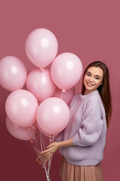 istock birthday girl posing with balloons 1217602650