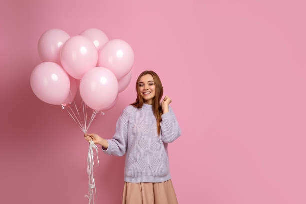 istock birthday girl posing with balloons 1217602730