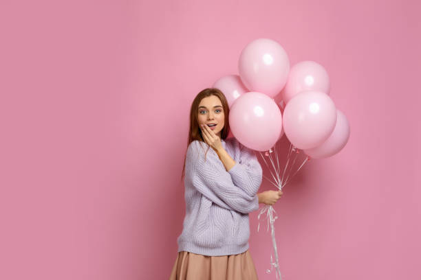 istock birthday girl posing with balloons 1217602827