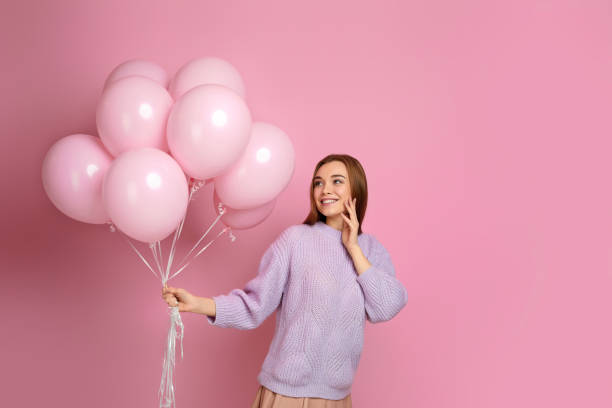 istock birthday girl posing with balloons 1217602836