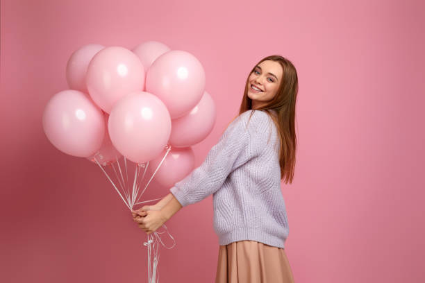 istock birthday girl posing with balloons 1217602900