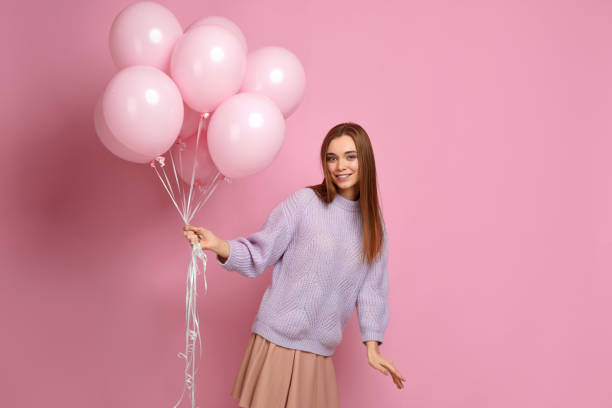 istock birthday girl posing with balloons 1217602959